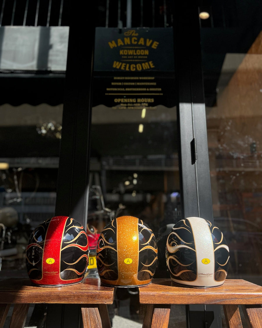 Three decorative bottles with flame patterns on a wooden surface, with a 'Man Cave' sign in the background.
