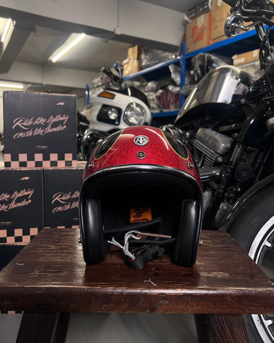 Red motorcycle helmet on a wooden table with motorcycles in the background
