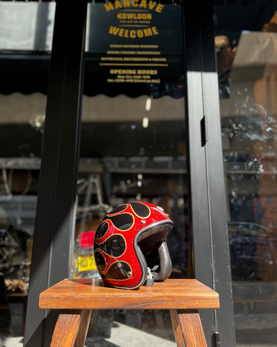 Red and black helmet on a wooden stool with a store entrance in the background