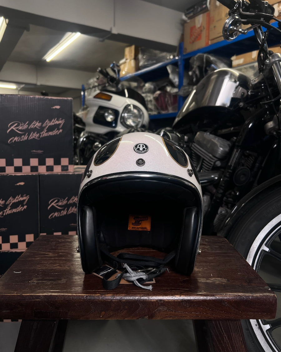 White motorcycle helmet on a wooden table with motorcycles in the background