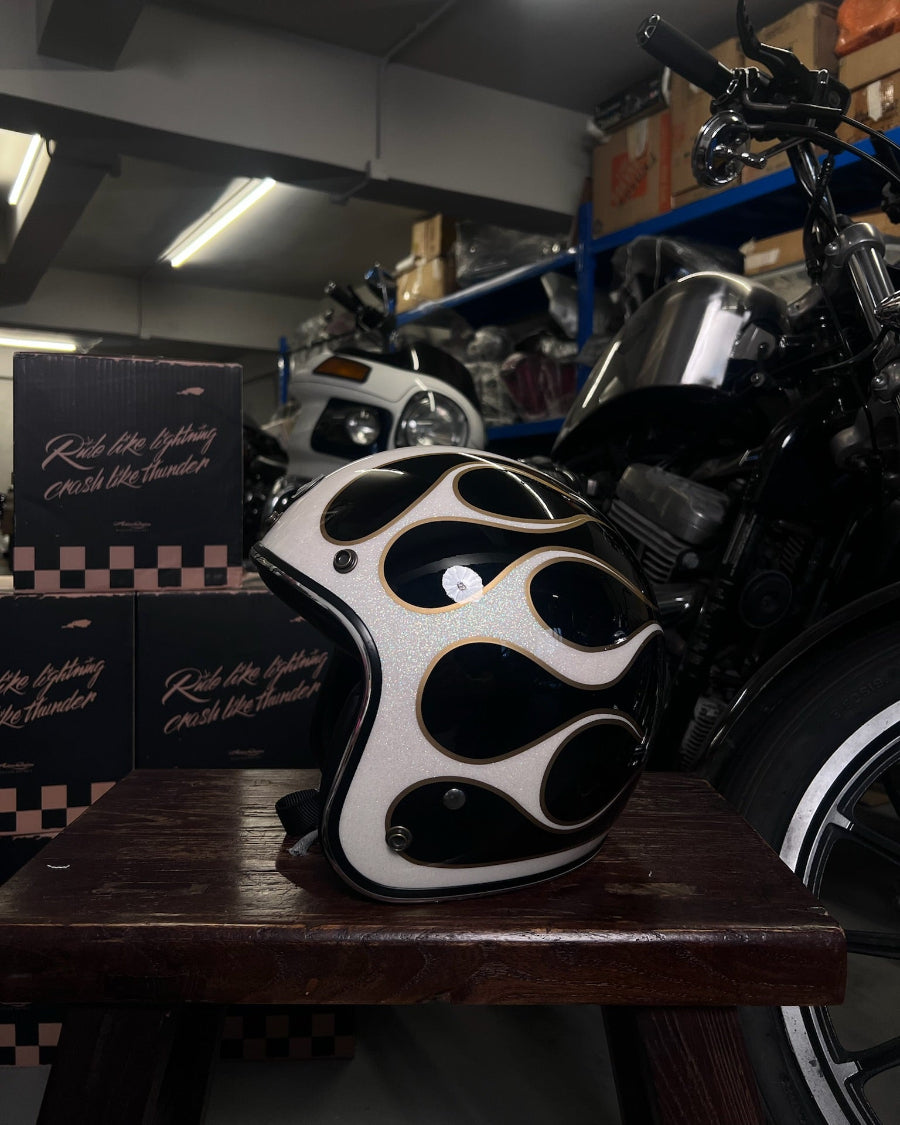 Flamed motorcycle helmet on a stand with motorcycles in the background