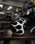Black and white helmet with flame design on a wooden table in a garage setting