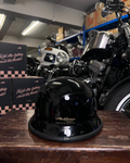 Black helmet on a wooden surface with motorcycles in the background