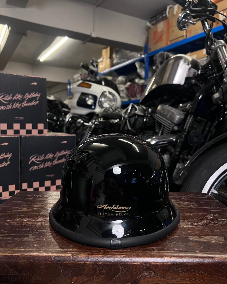 Black helmet on a wooden surface with motorcycles in the background
