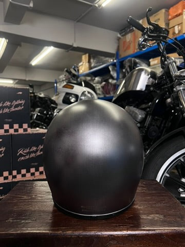 Black helmet on a wooden surface with motorcycles in the background