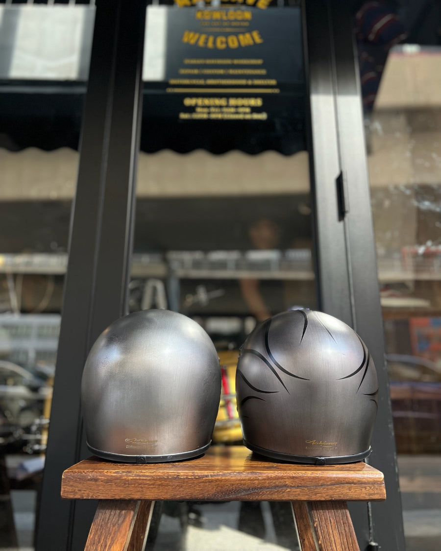 Two motorcycle helmets on a wooden stand with a blurred background