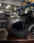 Motorcycle helmet on a wooden surface with a motorcycle in the background