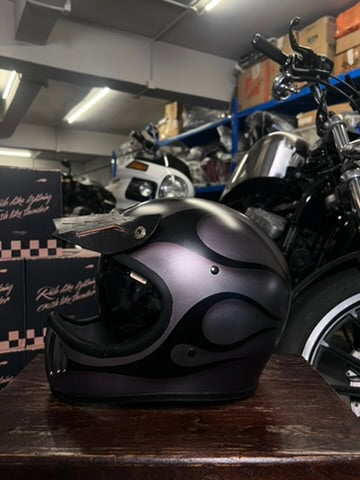 Motorcycle helmet on a wooden surface with a motorcycle in the background