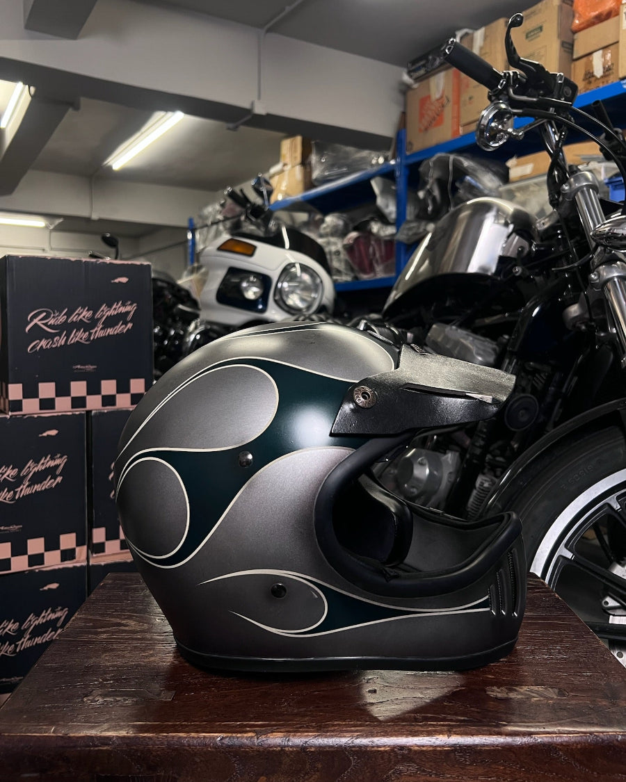 Motorcycle helmet on a table with a motorcycle and boxes in the background