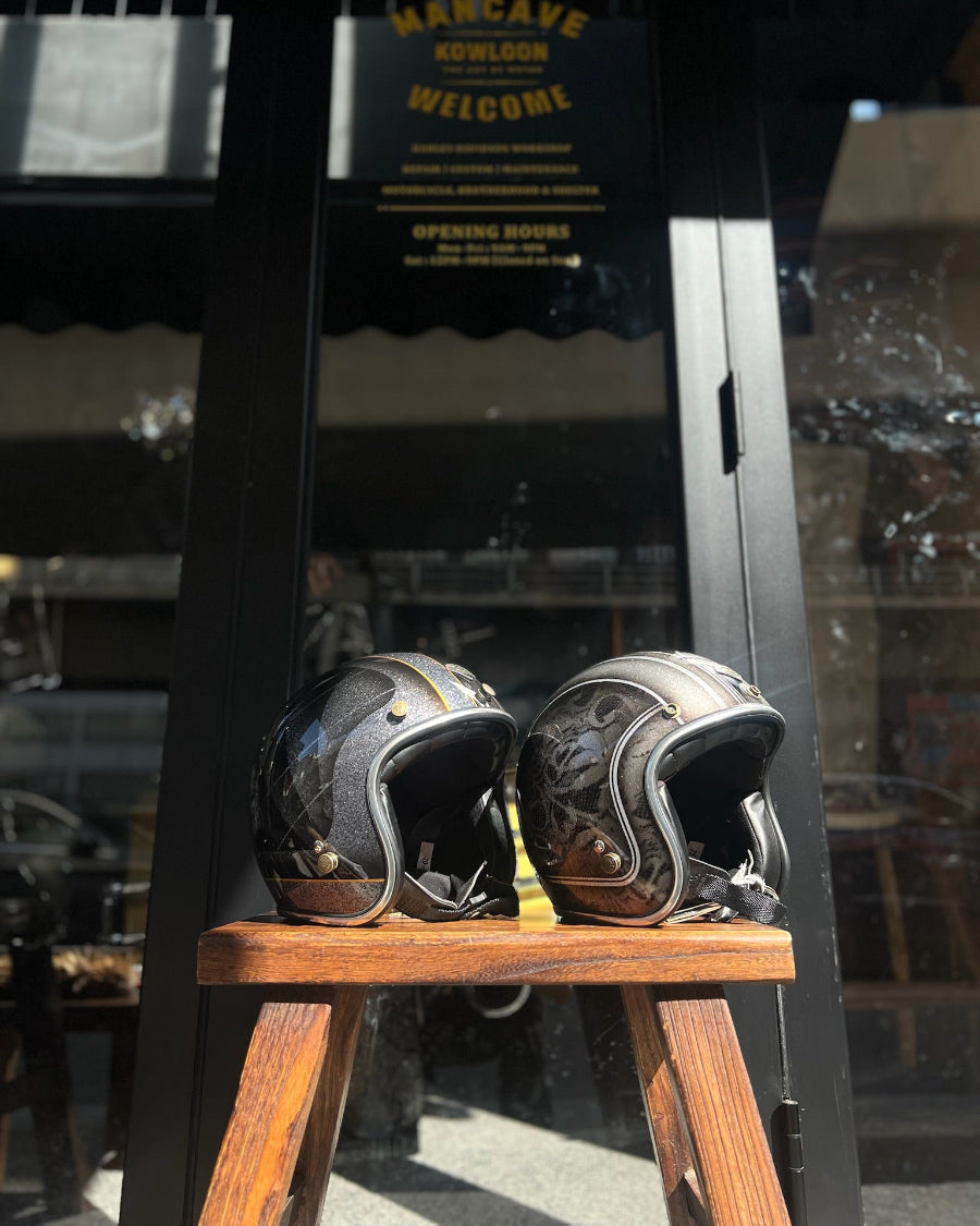 Two motorcycle helmets on a wooden stool with a store entrance in the background.