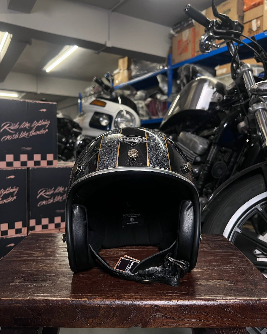 Black motorcycle helmet on a wooden table with motorcycles in the background
