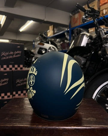 Black motorcycle helmet with yellow design on a wooden surface in a garage setting