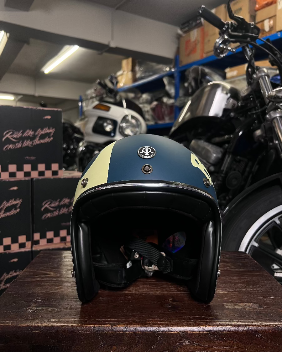 Motorcycle helmet on a wooden surface with motorcycles and boxes in the background