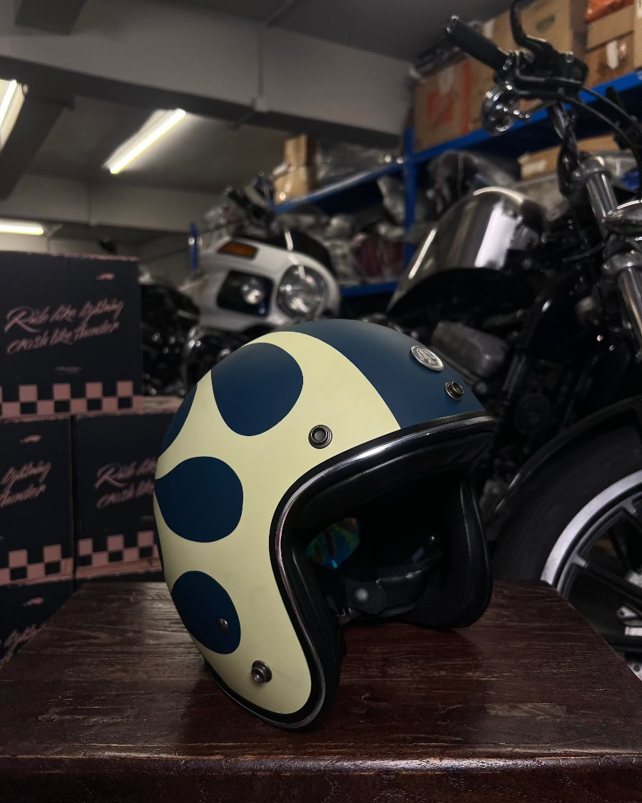 Polka dot helmet on a wooden surface with motorcycles in the background