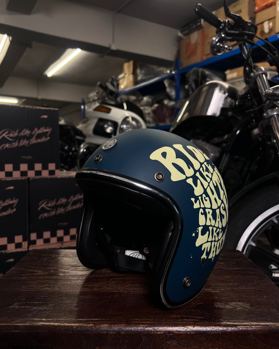 Blue helmet with yellow text on a wooden surface in a garage setting