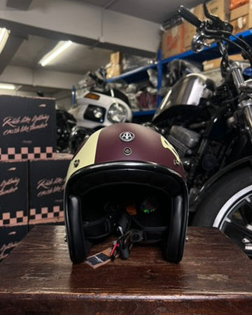 Motorcycle helmet on a wooden surface with motorcycles in the background