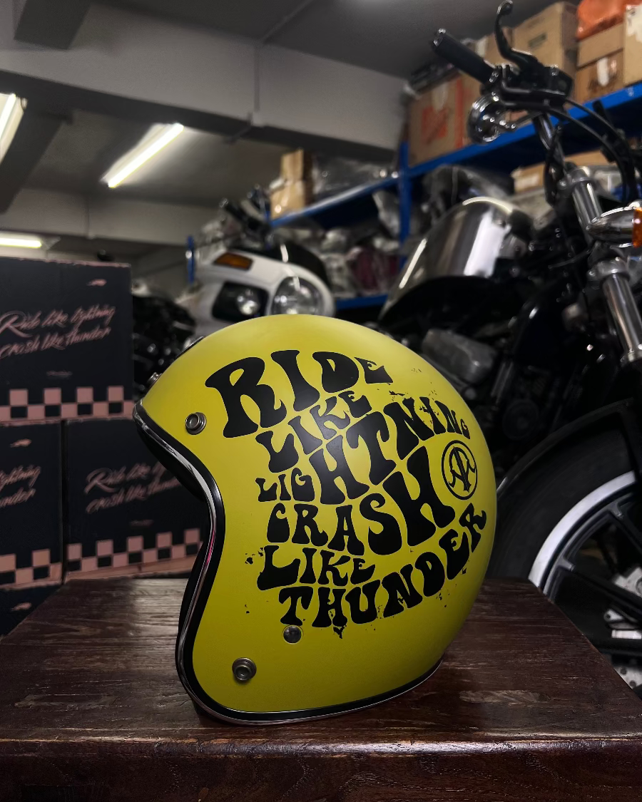 Yellow motorcycle helmet with text in a garage setting