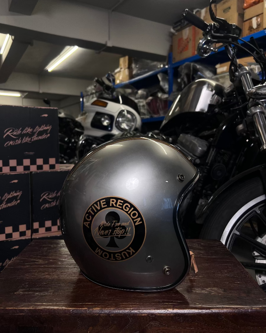 Motorcycle helmet with 'Active Region' logo on a wooden surface in a garage setting.