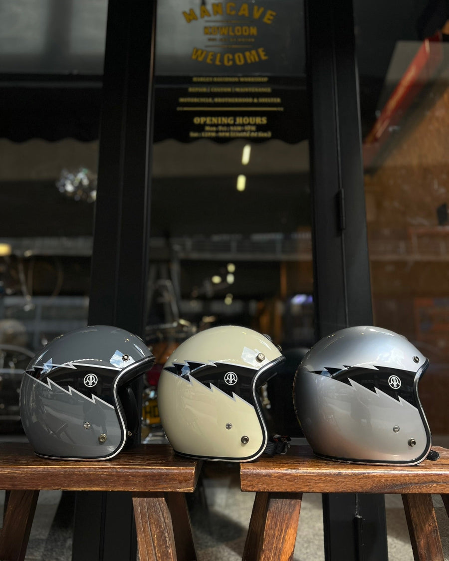 Three motorcycle helmets on a wooden table with a blurred background