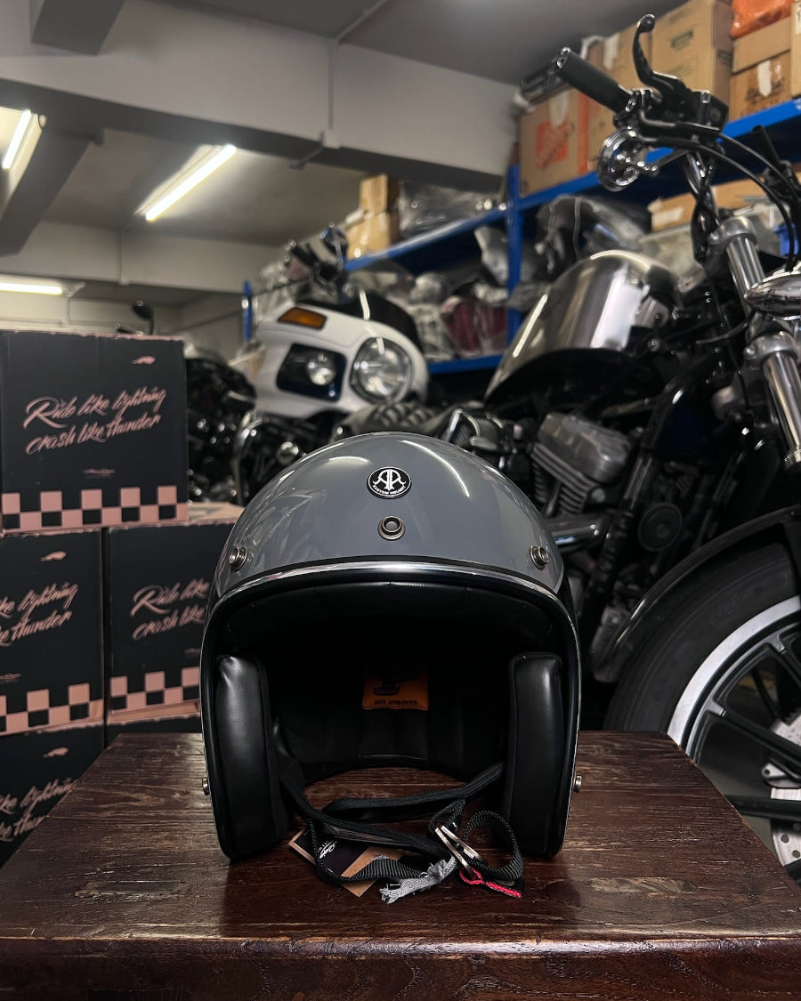 Motorcycle helmet on a wooden surface with motorcycles and boxes in the background