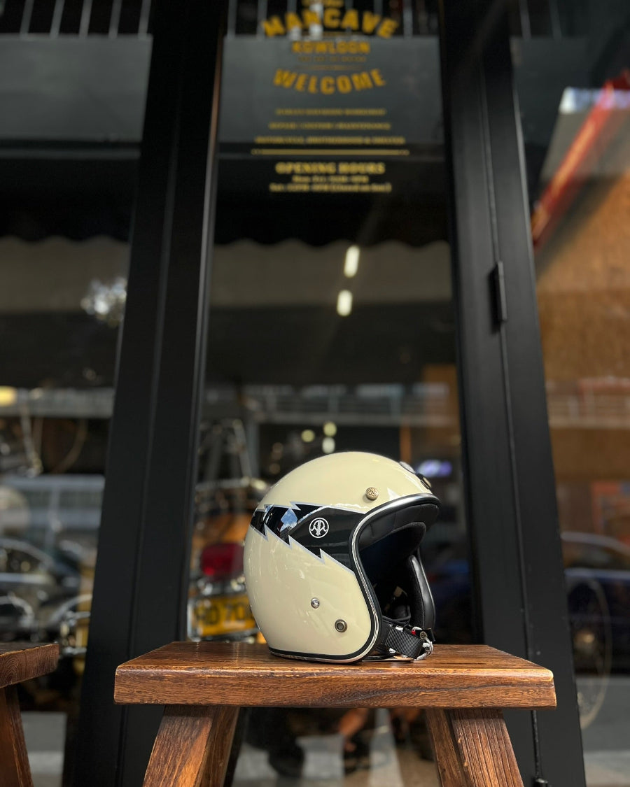 White helmet with black accents on a wooden stool in front of a store entrance.